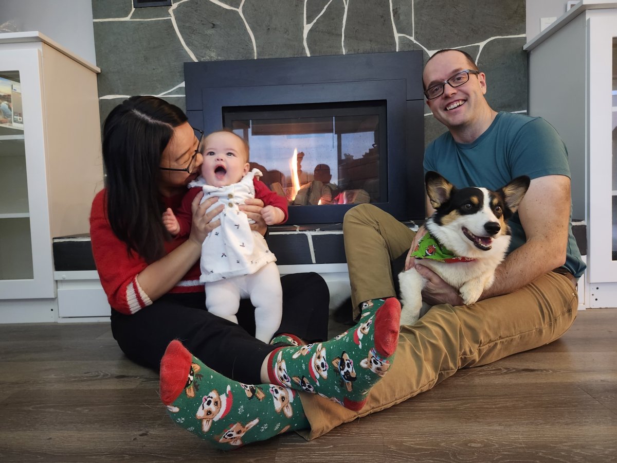 Erich Kamprath, owner and home inspector at At Ease Property Inspections, sitting with his wife, baby daughter, and family dog inside their home. The image reflects the importance of safe, well-maintained living spaces for growing families. As a professional home inspector, Erich understands firsthand how careful inspection, attention to detail, and informed home-buying decisions help protect the places where families build their lives and create lasting memories.