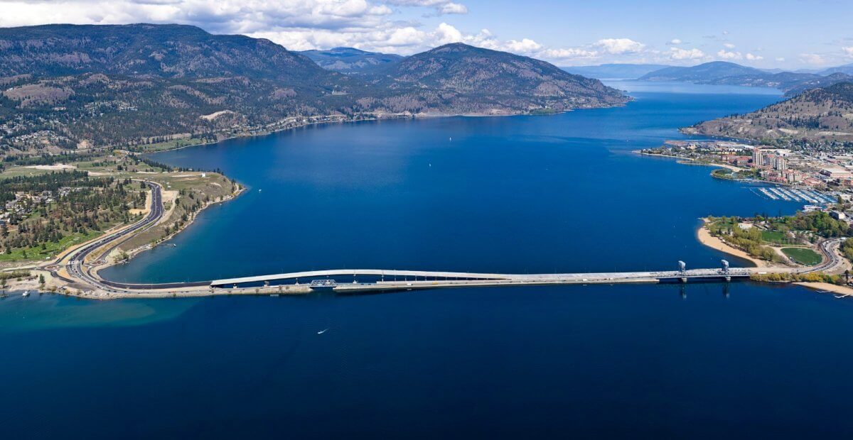 Aerial view of Okanagan Lake and surrounding hills in the Okanagan, illustrating the hot, dry climate and high sun exposure common in the area. Log home inspections in this region focus on UV exposure, prolonged dryness, finish wear, and how log surfaces manage moisture near lakes, irrigation zones, and sloped terrain typical of Okanagan properties.