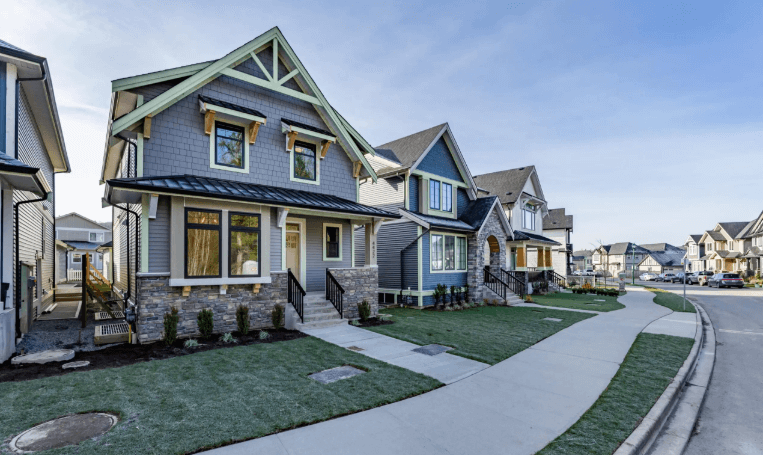 A row of modern new-build homes featuring stone accents and contemporary siding; Erich Kamprath of At Ease Property Inspections provides comprehensive new construction inspections to ensure quality from the ground up.